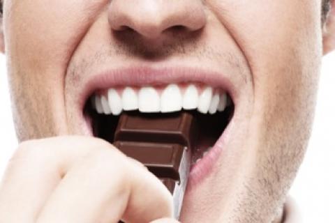 Hombre comiendo chocolate para reducir el riesgo de ictus