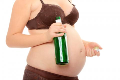 Mujer embarazada con una botella en la mano