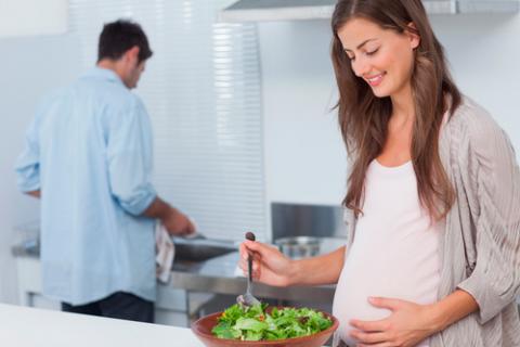 Embarazada preparando una ensalada