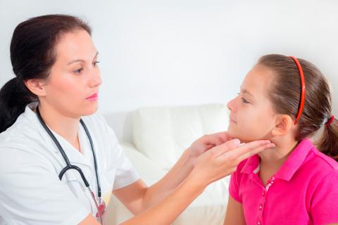 Una doctora examina las glándulas adenoides a una niña