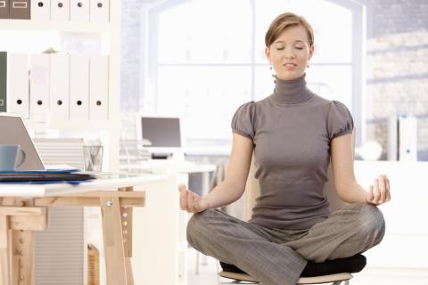 Mujer haciendo yoga en la oficina