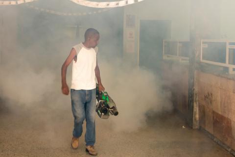 Persona fumigando una escuela en Cuba
