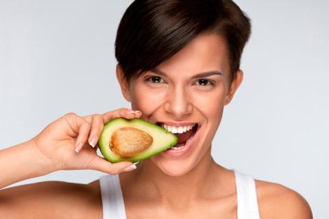 Mujer comiendo aguacate
