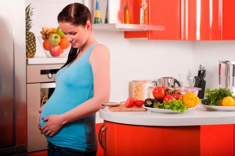 Mujer embarazada en la cocina