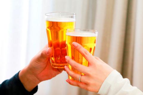 Dos personas brindan con cerveza