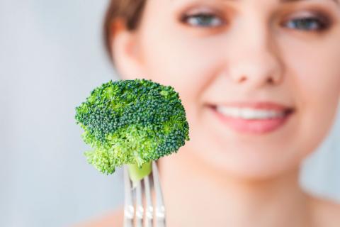 Mujer tomando brócoli