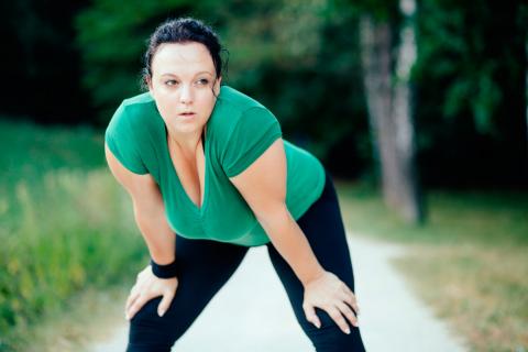 Una mujer con sobrepeso practica ejercicio al aire libre