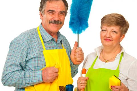 Una pareja de adultos mayores preparados para realizar labores domésticas