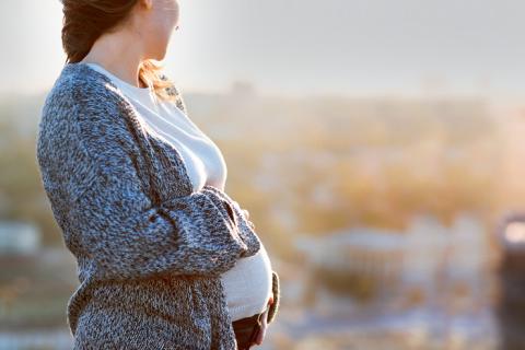 Mujer embarazada en la ciudad con aire contaminado