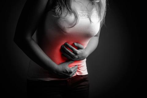 Una mujer se agarra el abdomen dolorido