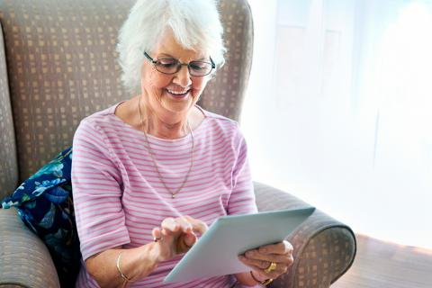 Una mujer mayor navega por Internet con una tablet