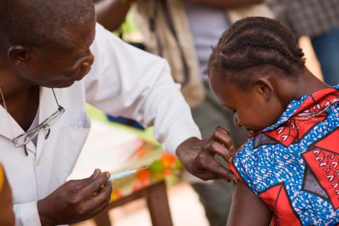 Un sanitario vacuna a una niña contra la fiebre amarilla