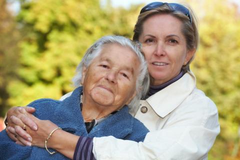 Una mujer abraza a una anciana