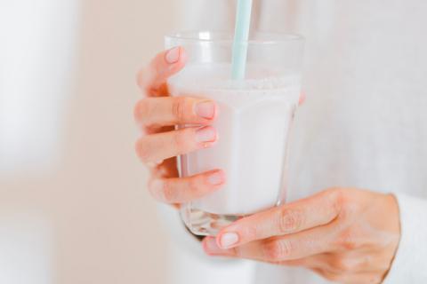 Mujer tomando vaso de leche entera