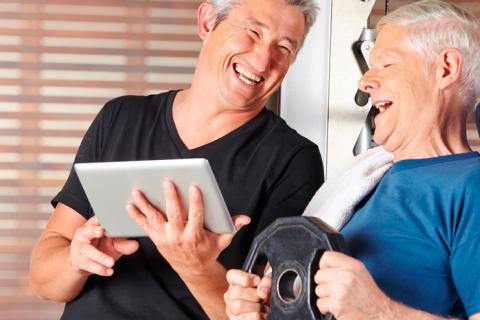 Un hombre mayor muestra a otro su tablet con la aplicación