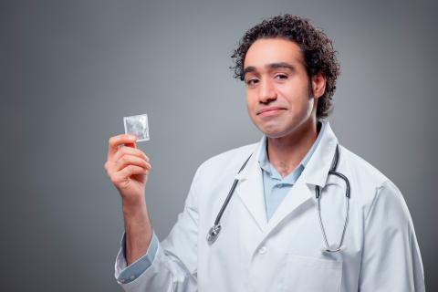 Un profesional sanitario sostiene un preservativo en su mano