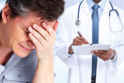 Hombre con dolor de migraña espera la receta de su médico