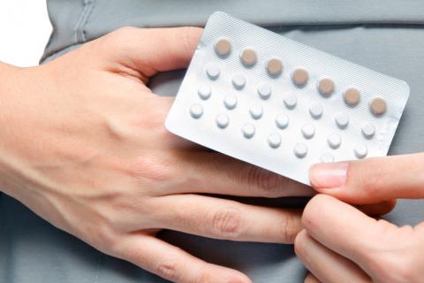Persona tomando píldoras anticonceptivas para tratar el ovario poliquístico