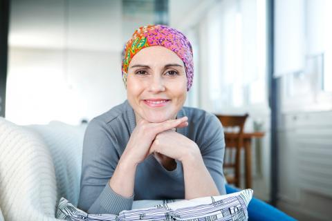 Mujer en tratamiento con quimioterapia sonríe a la cámara