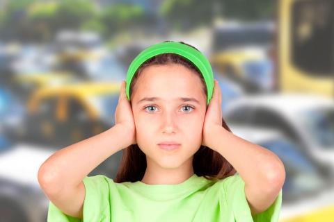 Una niña se tapa los oídos con las manos