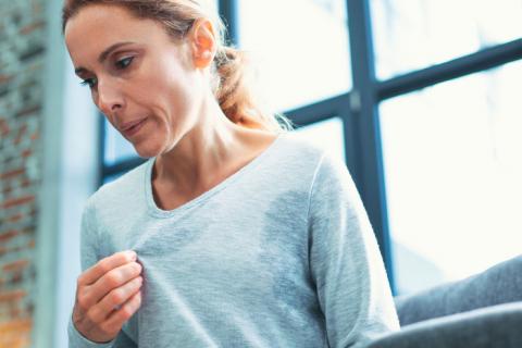 Mujer sufriendo los sofocos típicos de la menopausia
