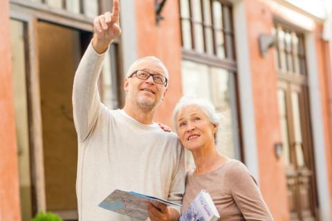 Una pareja de adultos mayores consulta una guía de viaje en una ciudad