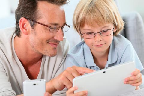 Padre e hijo mirando una tablet y smartphone