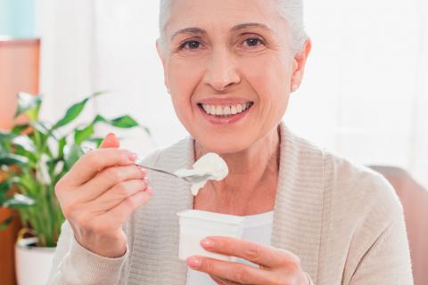 Mujer adulta tomando yogur para prevenir cataratas
