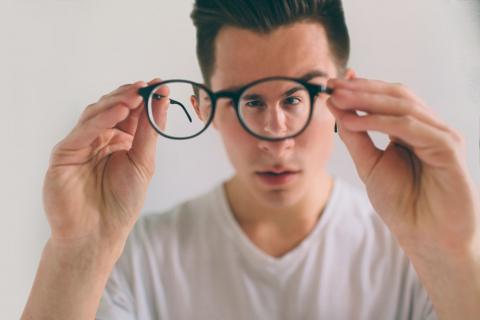 Persona con astigmatismo sostiene sus gafas