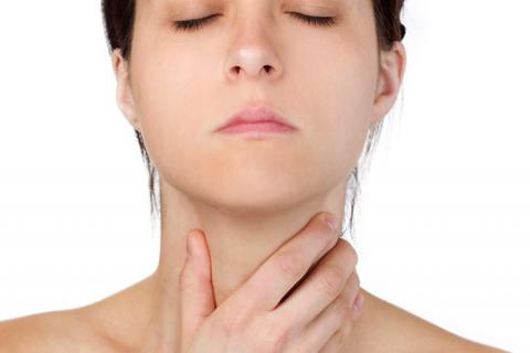 Afectada por cáncer de tiroides con mano en la garganta