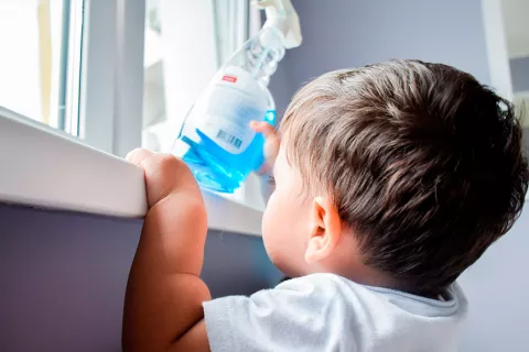 Niño cogiendo producto de limpieza tóxico