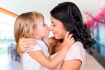 Una mujer abraza a su hija, que la besa en la nariz