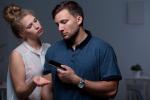 Mujer reclamándole el móvil a su pareja como concepto de gaslighting o manipulación