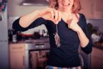 Mujer en la cocina grita mientras sujeta un ratón por la cola