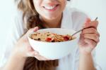 Mujer tomando cereales, alimentos recomendados en el reflujo gastroesofágico