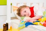 Niño con infección de orina tumbado en la cama