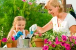 Actividades para disfrutar del slow parenting Una mujer con su hija plantando flores en el jardín