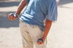 Beneficios físicos de jugar a la petanca para los mayores Hombre mayor jugando a la petanca