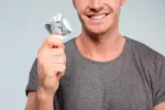 Ventajas e inconvenientes del preservativo masculino Hombre con un preservativo en las manos