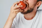 Propiedades nutricionales del tomate Hombre mordiendo un tomate