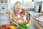 Madre jugando con su hija en la cocina