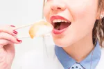 Causas de intoxicación por anisakis Mujer comiendo pescado crudo