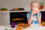 Claves para que los niños aprendan a comportarse en la mesa Niña aprendiendo a comportarse en la mesa