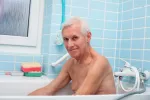 Cómo se debe adaptar el baño para una persona mayor Hombre mayor en el interior de la bañera