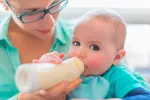 Composición nutricional de las leches de crecimiento Una madre alimenta a su hijo con un biberón