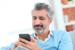 Consejos para buscar y encontrar empleo a los 50 Hombre con 50 años buscando empleo por el móvil
