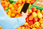 Aplicaciones móviles para el día a día de los mayores Una persona mayor consulta su móvil en el supermercado
