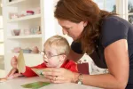 Cómo se trabaja la terapia miofuncional: ejemplos de ejercicios Una mujer enseña a un niño pequeño a realizar ejercicios