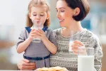 Madre e hija bebiendo un vaso de leche