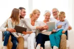Aplicaciones para potenciar la relación familiar en personas mayores Padres, hijos y nietos manejan juntos una tablet